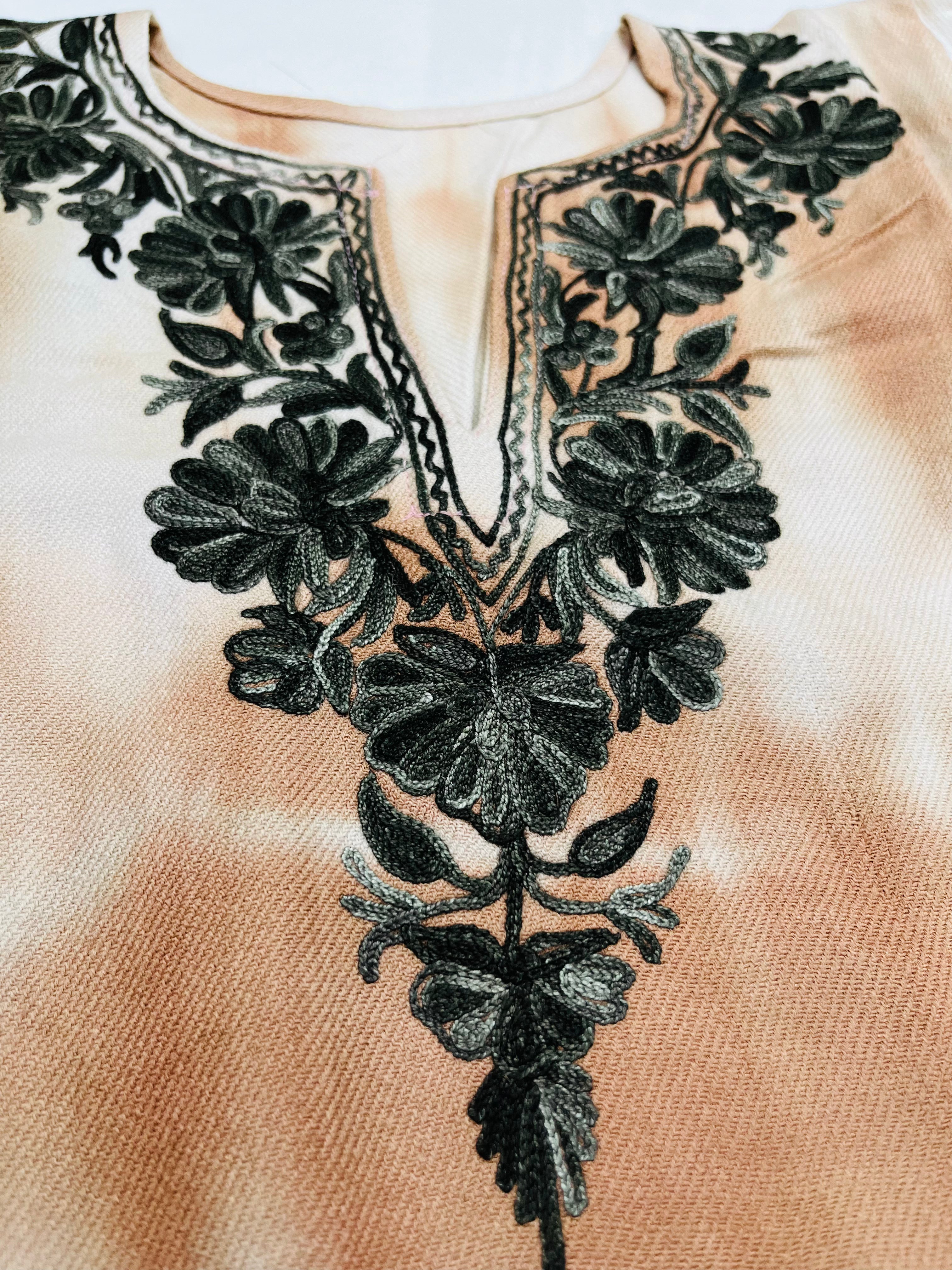 Close-up of a beige Pheran with black floral embroidery